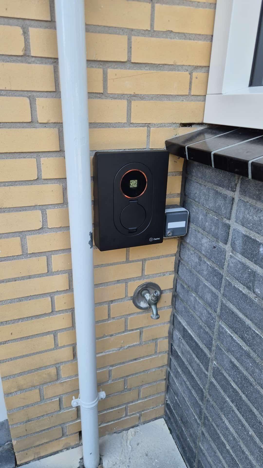 Afgewerkte laadpaal tegen een gevel